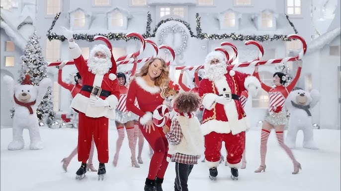 Mariah Carey entourée de Pères Noël