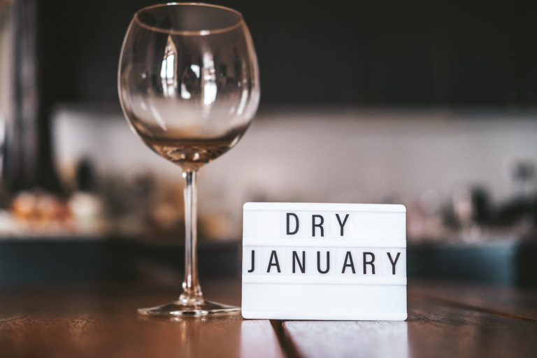 Verre de vin vide avec une pancarte "Dry January"