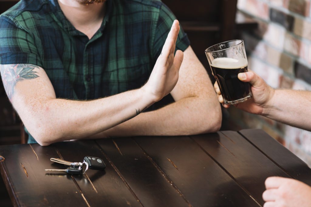 Un homme refusant un verre de rhum